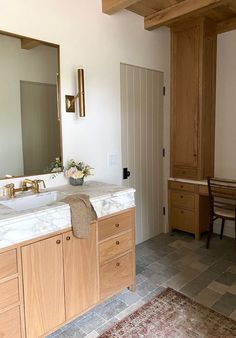 a bathroom with double sinks and wooden cabinets