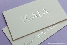 two business cards with the letters aa and aa on them are laying side by side