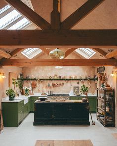 a kitchen with green cabinets and wooden beams