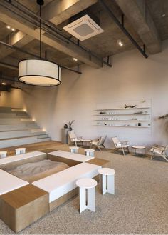 an empty room with several tables and chairs on the floor in front of some stairs