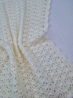 a white crocheted blanket laying on top of a table