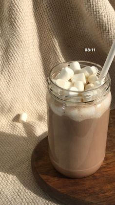 a jar filled with marshmallows on top of a wooden tray