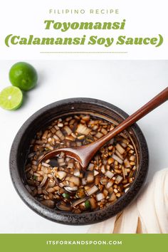 a bowl full of food with a spoon in it and limes on the side