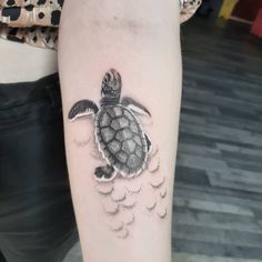 a small turtle tattoo on the right forearm and arm, with clouds coming out of it