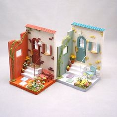 two paper model houses sitting on top of each other