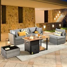 an outdoor living room with grey wicker furniture