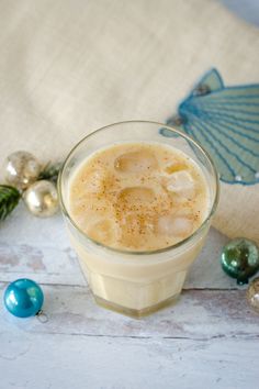 a drink in a glass sitting on top of a table next to ornaments and decorations