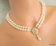 "This romantic double strand necklace has a victorian style rose pendant with clear stones set on an antique gold filigree. I have used Swarovski pearls in ivory/cream. All the Swarovski crystals in the pendant are handset by me. Pearls measure 8 mm in both strands accented with rhinestone beads. Rhinestone pendant is just under 1\" in diameter. Necklace is 17\" long inner strand. Finished off with antique gold finish filigree clasp adorned with Swarovski crystals. It comes with a 2\" extender c Gold Pearl Embellished Necklaces For Wedding, Exquisite Pearl White Wedding Necklace, Gold Pearl Bridal Necklace For Mother Of The Bride, Mother Of The Bride Gold Pearl Bridal Necklace, Gold Pearl Chain Necklace For Mother Of The Bride, Exquisite Pearl Wedding Necklace, Wedding Necklace Pearl, Bridal Jewelry Pearl, Pearl Wedding Necklace