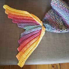 a multicolored knitted hat sitting on top of a couch