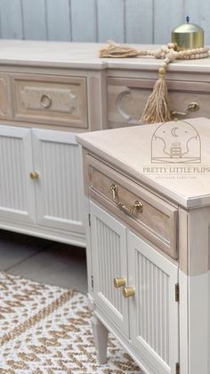 a white and beige dresser sitting on top of a rug