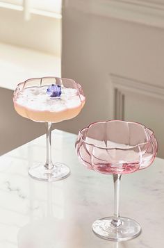 two wine glasses sitting on top of a counter