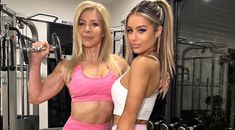 two women standing next to each other in front of a gym equipment rack with dumbs