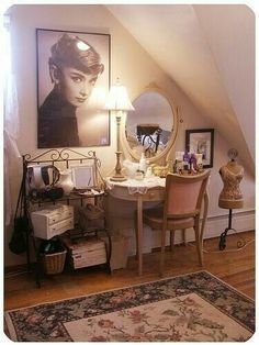 a room with a desk, chair and mirror in it next to a painting on the wall