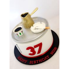 a birthday cake that is decorated with a number 37 and coffee mugs on it