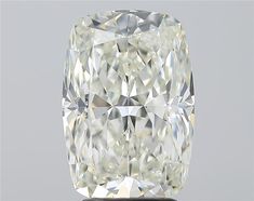 a cushion cut diamond sitting on top of a metal stand in front of a gray background