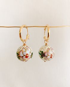 ✤14kt gold filled hoops: 15mm ✤cloisonné charms: 18mm  Artful and eye-catching vintage inspired gold cloisonné drop hoop earrings featuring white floral enamel charms. Small gold filled hoops latch securely.  SHIPPING: ✤I offer FREE shipping within Canada but please note that this does NOT include tracking. If you choose FREE shipping, you risk your package getting lost in transit. If this happens, I CANNOT issue you a refund or replace your jewelry. ✤Only TRACKED orders include tracking. This option is the ONLY method of shipping that ensures you will receive your package or that you can receive a full refund or replacement should your package go missing. GOOD STUFF ✤Become an A/R INISIDER at https://adornedbyruth.com/ to get first peeks at new releases & discounts  ✤Instagram: @adornedby White Enamel Hoop Earrings For Gifts, Enamel Ear Wire Jewelry, White Enamel Small Hoop Earrings, White Hand Painted Drop Earrings, Small Hoop Enamel Earrings For Gift, Enamel Small Hoop Earrings For Gift, Gold Enamel Dangle Hoop Earrings, Small Hoop Enamel Earrings Gift, Handmade White Enamel Earrings