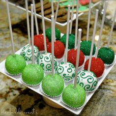 green and red cake pops are on a tray