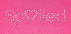 the word love spelled out in small letters on a pink background with silver and white beads