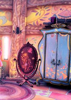 the room is decorated in pink, blue and yellow with an ornate armoire next to it