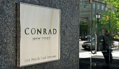 a sign on the side of a building that reads conrad new york 100 north park avenue