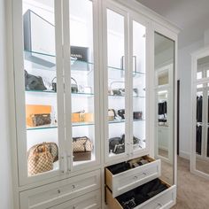 a white closet filled with lots of purses and handbag's in it