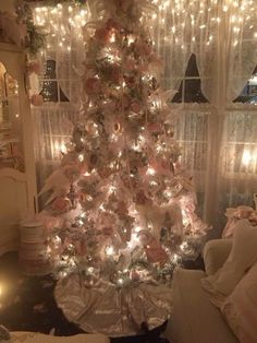 a decorated christmas tree in a living room with fairy lights on the windowsills