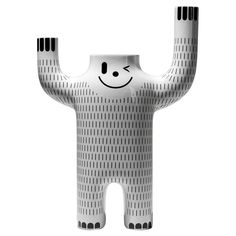 a large white sculpture with a smiley face on it's body and arms in the air