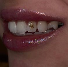 a close up of a person's mouth with white teeth and gold stars on it