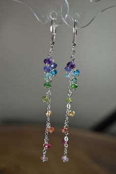 "These Long Ombre Rainbow Cluster Earrings present gemstones in a minimal and timeless way. The gemstones display the colors of the rainbow (and them some) as they descend. These Earrings are a perfect addition to your everyday attire and suitable for all special occasions, from weddings to special events. Each gemstone displays a lot of beauty and energy. Though these earrings are designed to be minimalist, their color is still impactful and they are sure to brighten your day! >Rainbow, Rain Modern Handmade Rainbow Jewelry, Rainbow Sterling Silver Dangle Jewelry, Rainbow Gemstone Jewelry In Sterling Silver, Rainbow Sterling Silver Jewelry With Ear Wire, Rainbow Sterling Silver Earrings, Rainbow Dangle Jewelry For Everyday, Everyday Rainbow Dangle Jewelry, Elegant Rainbow Jewelry With Matching Earrings, Rainbow Elegant Jewelry Set With Matching Earrings