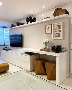 a living room filled with furniture and a flat screen tv on top of a wooden shelf