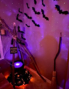 a room decorated for halloween with bats on the wall and purple lights in the ceiling