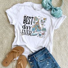 a t - shirt that says best day ever next to some sandals and a pair of jeans