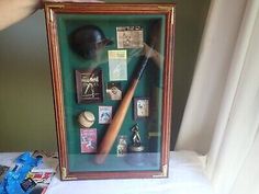 a baseball bat, helmet and other memorabilia in a shadow box