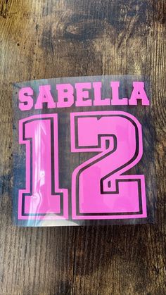 a pink sticker with the number twelve on it that says sabella 12th birthday