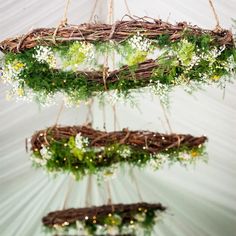 three hanging wreaths with flowers and greenery on them are suspended from the ceiling