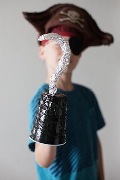 a young boy is holding up a beer can shaped like a horse's head