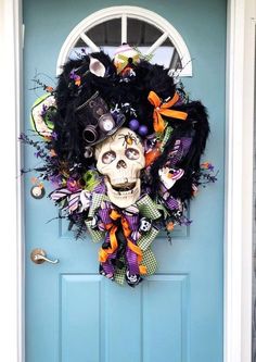 a blue door with a wreath decorated like a skeleton wearing a witch hat and eyeballs