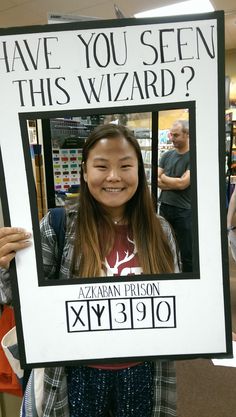 a woman holding up a sign with the words have you seen this wizard?