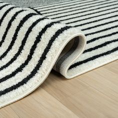 a black and white rug laying on top of a wooden floor