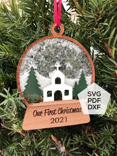 a christmas ornament hanging from a tree with the words our first christmas on it