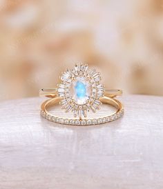 a ring with an oval shaped blue stone surrounded by small white and clear diamonds on top