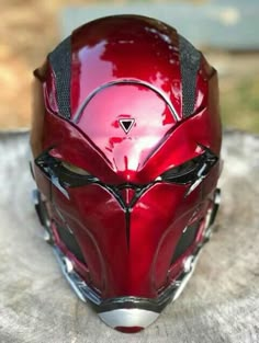 a close up of a red helmet on a wooden surface