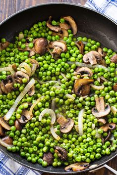 peas and mushrooms are cooking in a skillet