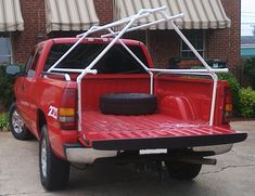 a red pick up truck parked in front of a brick building with awnings