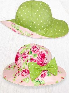 two hats with green and pink flowers on them, one has a bow at the top