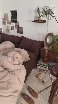 an unmade bed in a bedroom with lots of clutter on the floor next to it