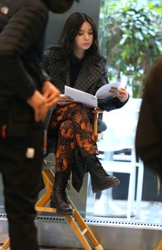 Actress Hailee Steinfeld sits in a set chair looking at a script in between takes of filming for the Hawkeye series. Haley Steinfeld, Aaron Taylor Johnson, Marvel Girls