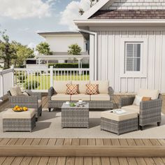 an outdoor patio furniture set on a wooden deck with white sidings and brown cushions