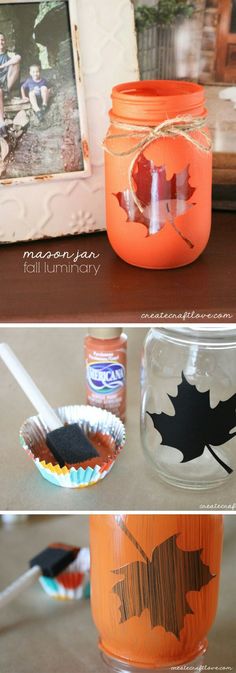 some jars with leaves painted on them are sitting on a table and one has a spoon in it