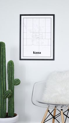 a white chair sitting next to a cactus in front of a wall with a map on it